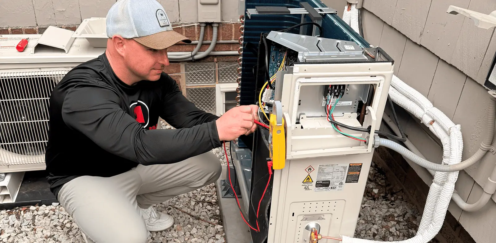 Anderson Heating & Cooling technician servicing an outdoor air conditioning unit